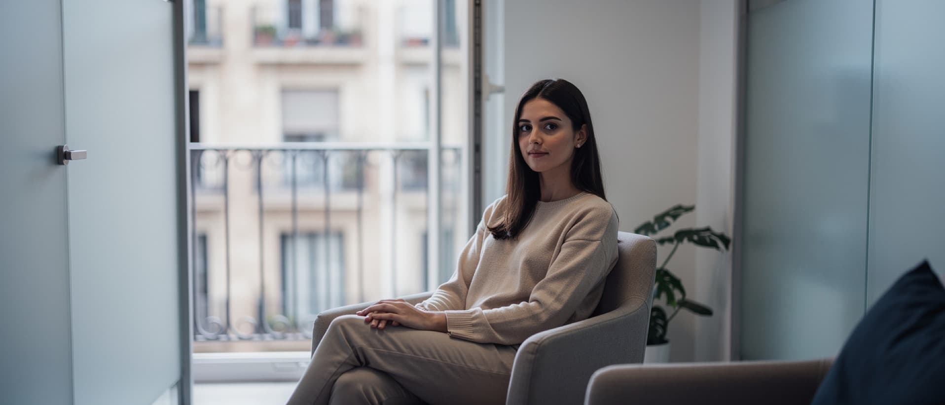 Young woman waiting behind frosted glass at a Barcelona fertility clinic, for egg donor compensation and anonymity