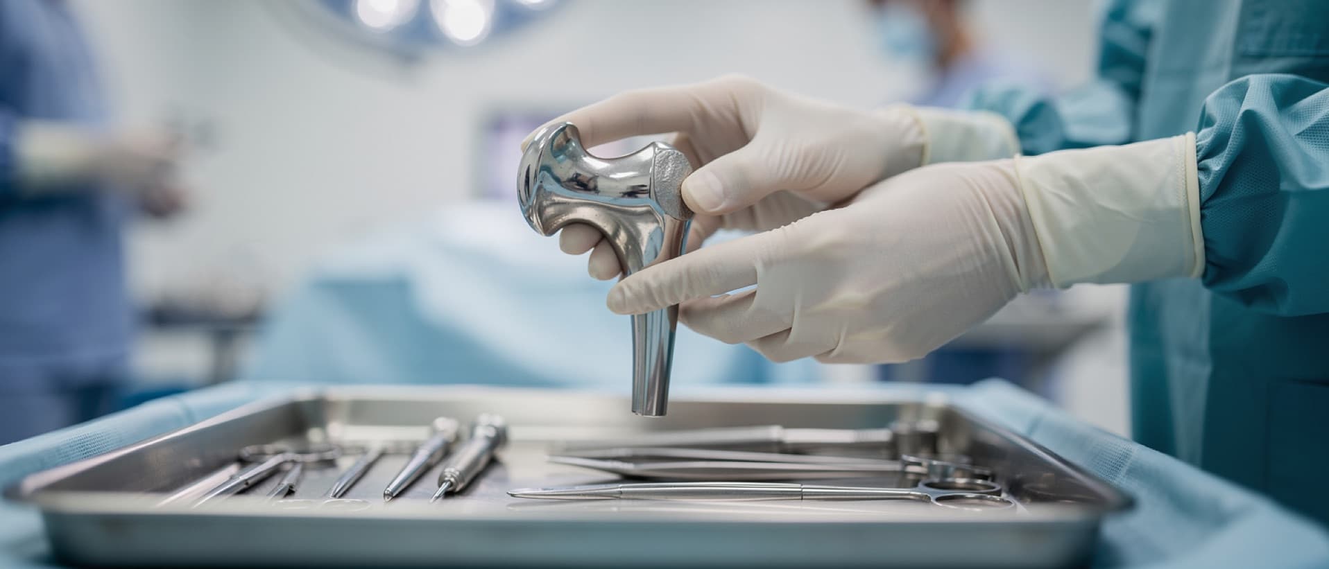 Surgeon holding a knee replacement implant, for National Joint Registry data on knee replacement abroad